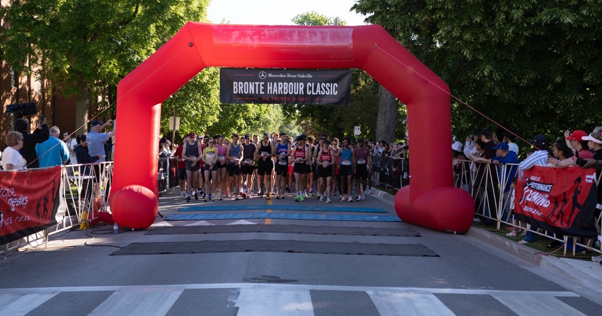 Runners at the start line of the Bronte Harbour Classic 5K in Oakville on a clear, sunny morning
